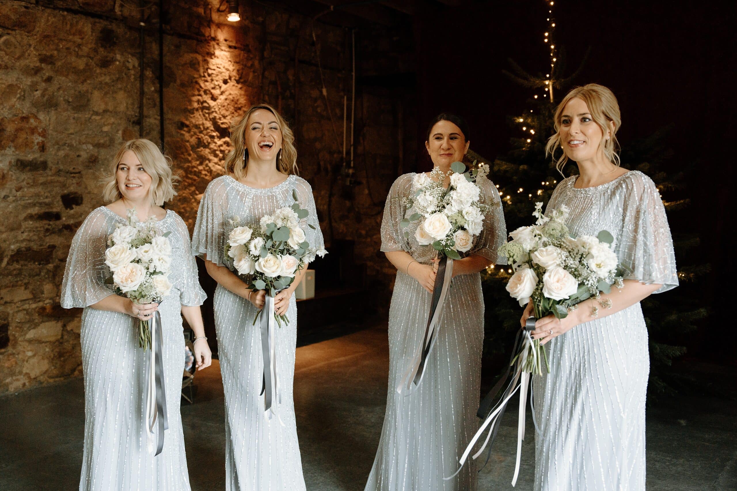 kinkell byre wedding photos bridesmaids in silver sparkly dresses waiting at the entrance to the venue