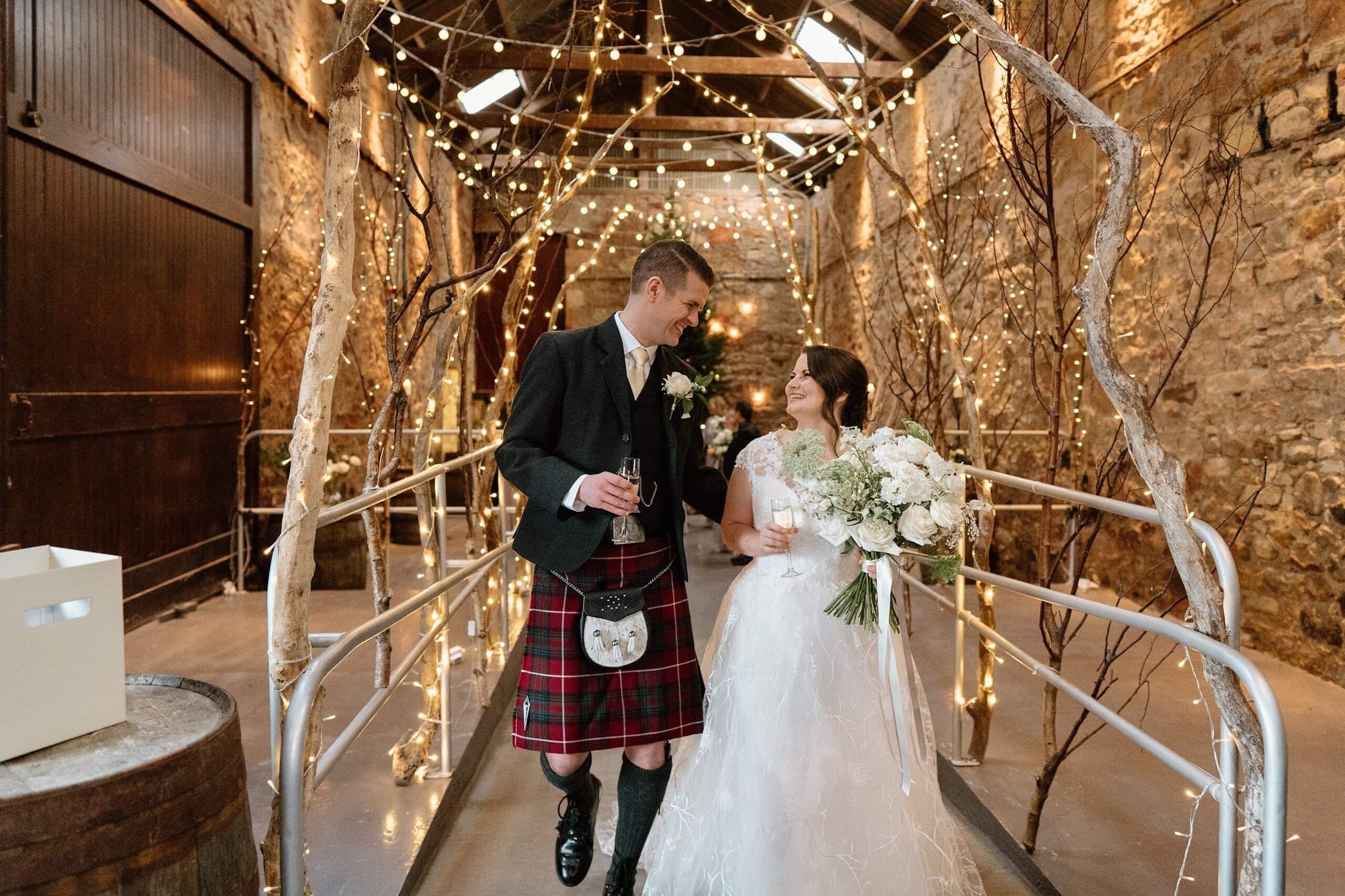 kinkell byre wedding photos interior inside view of farm barn wedding venue st andrews scotland ceremony setup with fairy lights with bride and groom