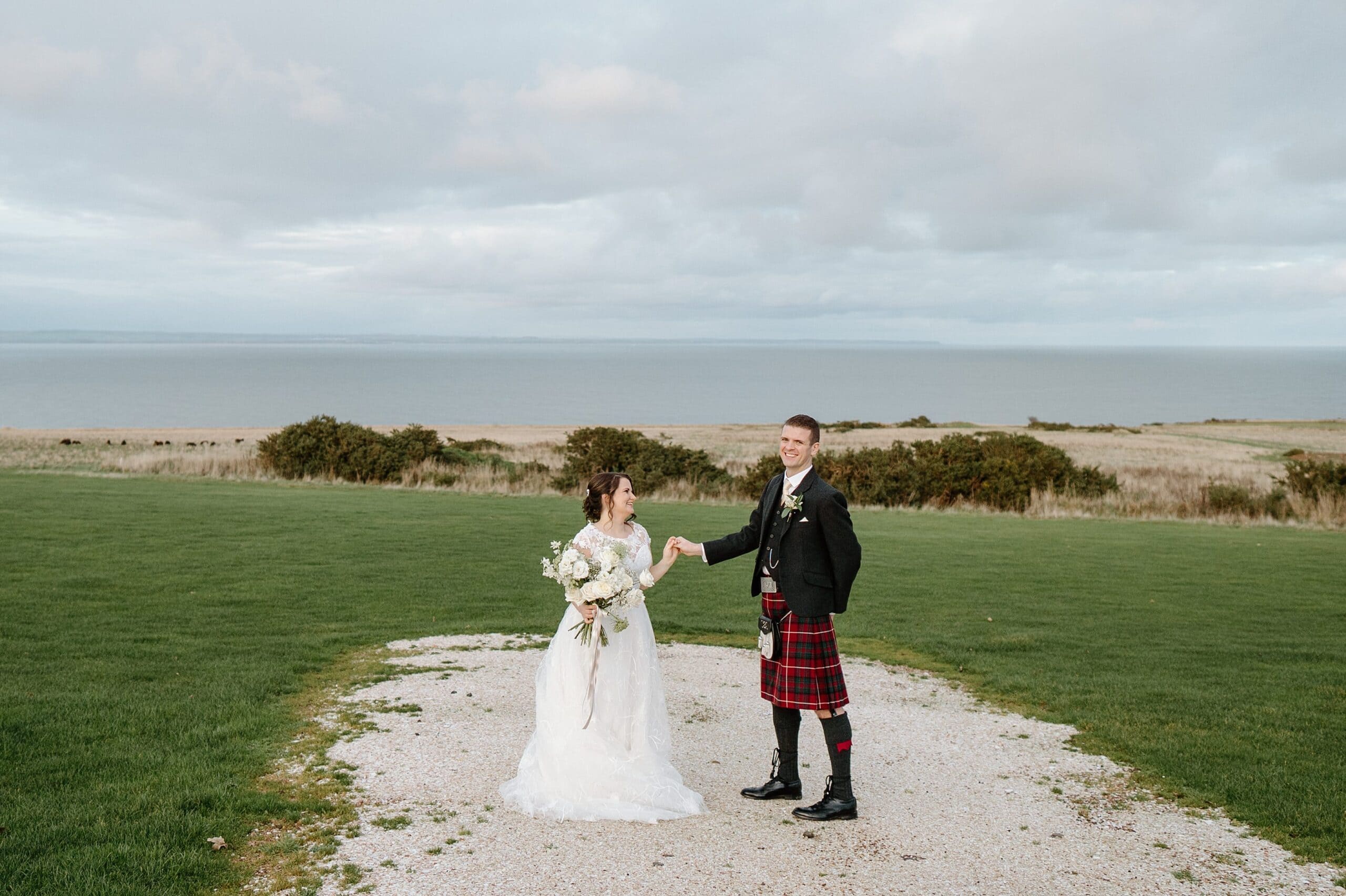 kinkell byre wedding photos of bride and groom outside venue with beach in the background