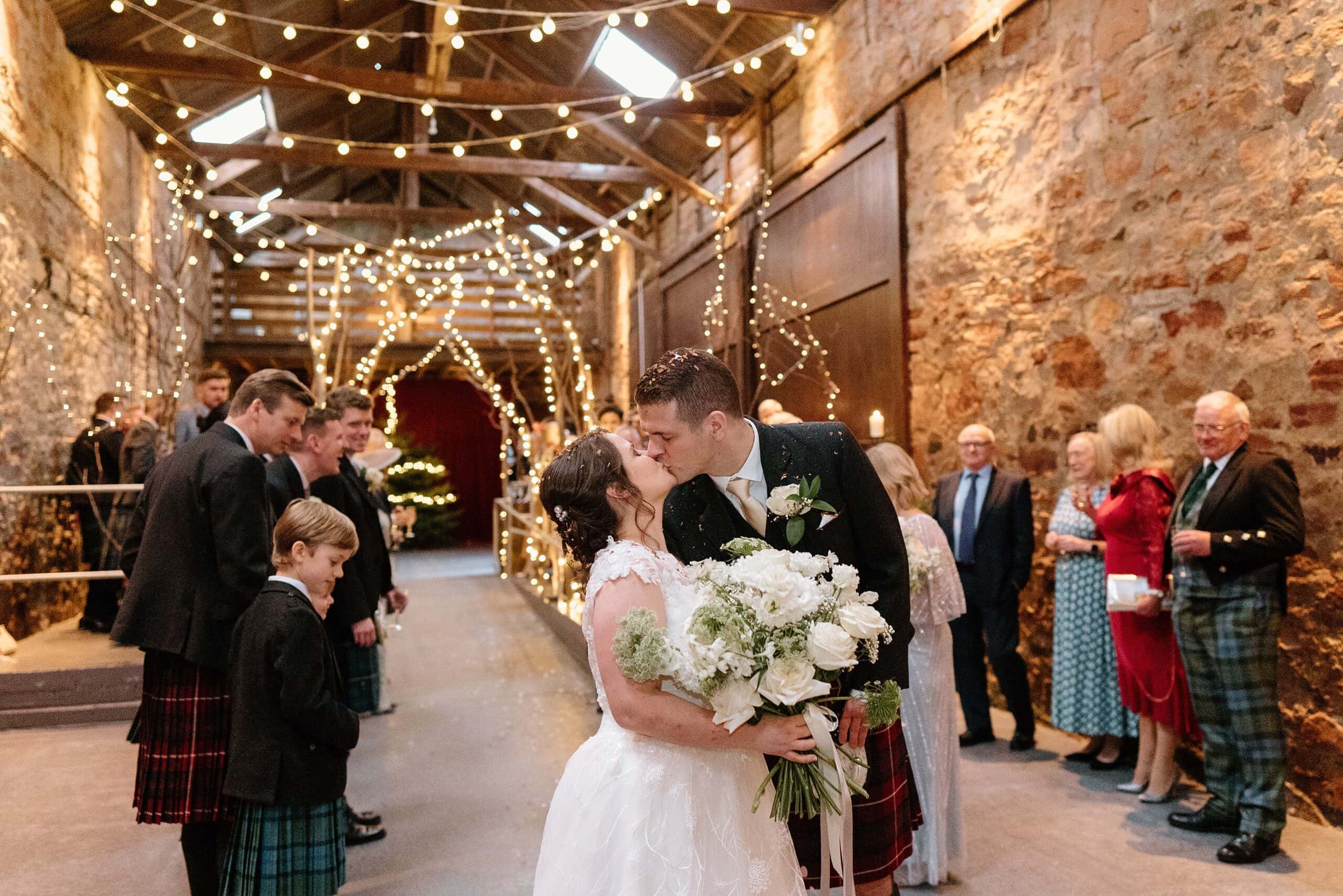 kinkell byre wedding photos interior inside view of farm barn wedding venue st andrews scotland with fairy lights with bride and groom