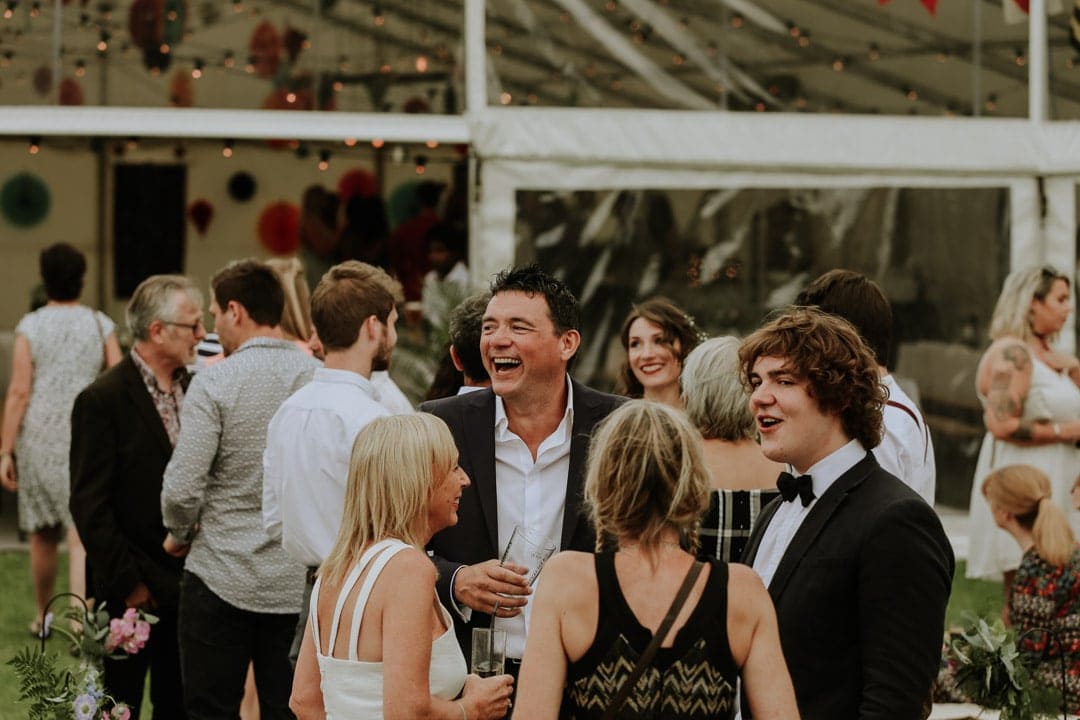 laughing-guests-drinking-champagne-leicestershire-marquee-wedding
