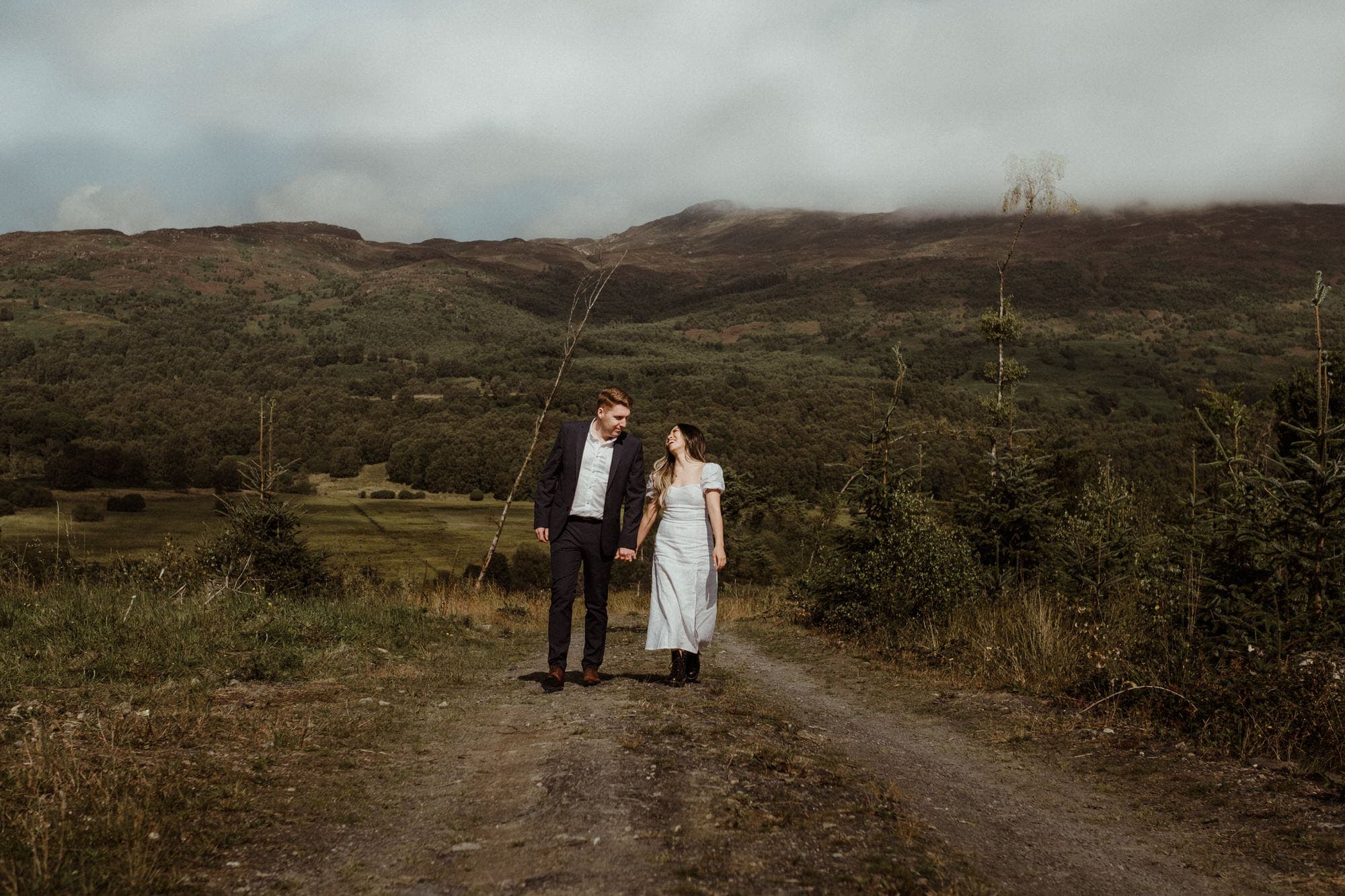 well dressed couple wander through the scottish countryside through hills and woods on their pre wedding shoot with christine who specialises in natural wedding photography scotland