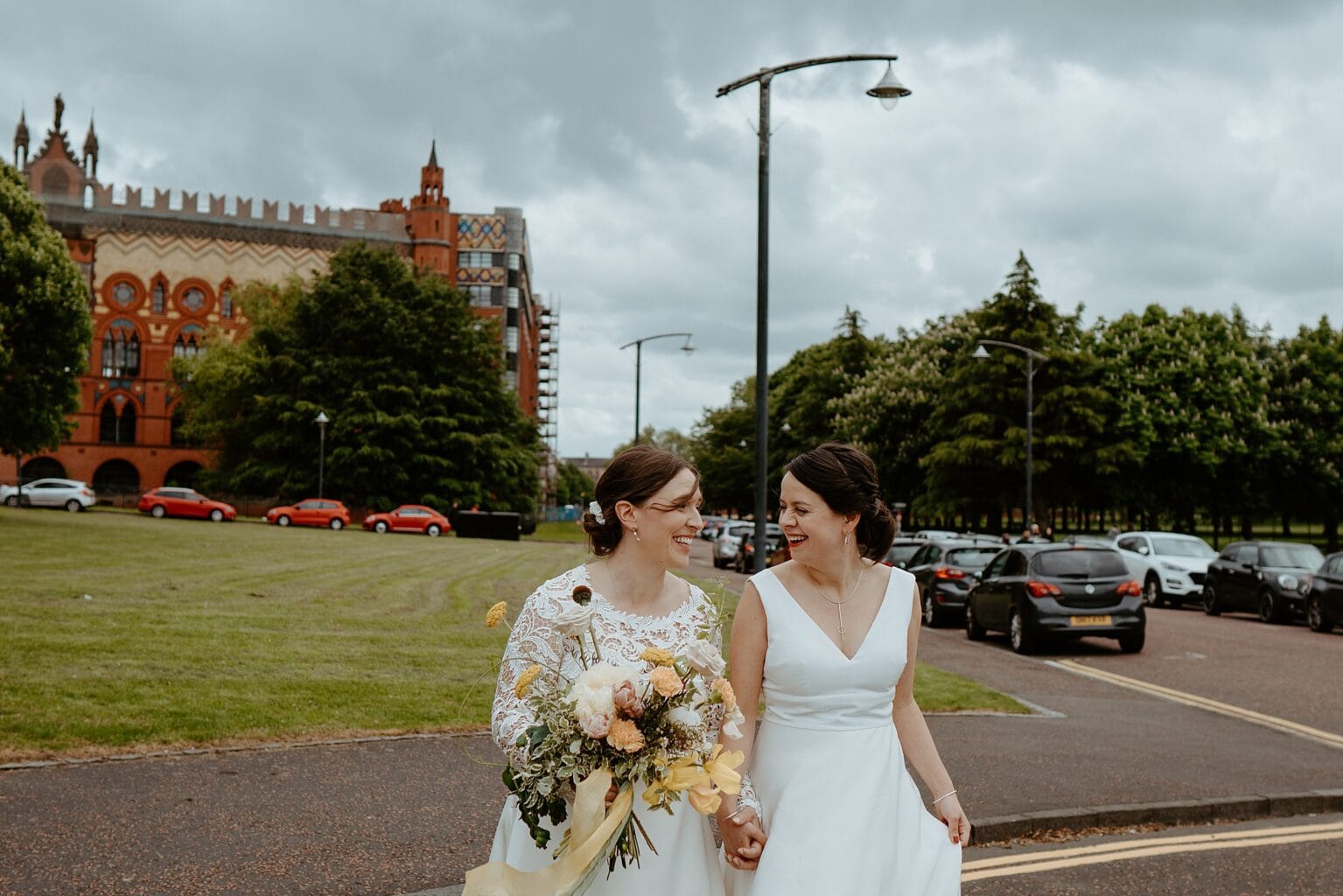 brides holding hands and crossing road outside of venue west on the green wedding exclusive use wedding venues scotland