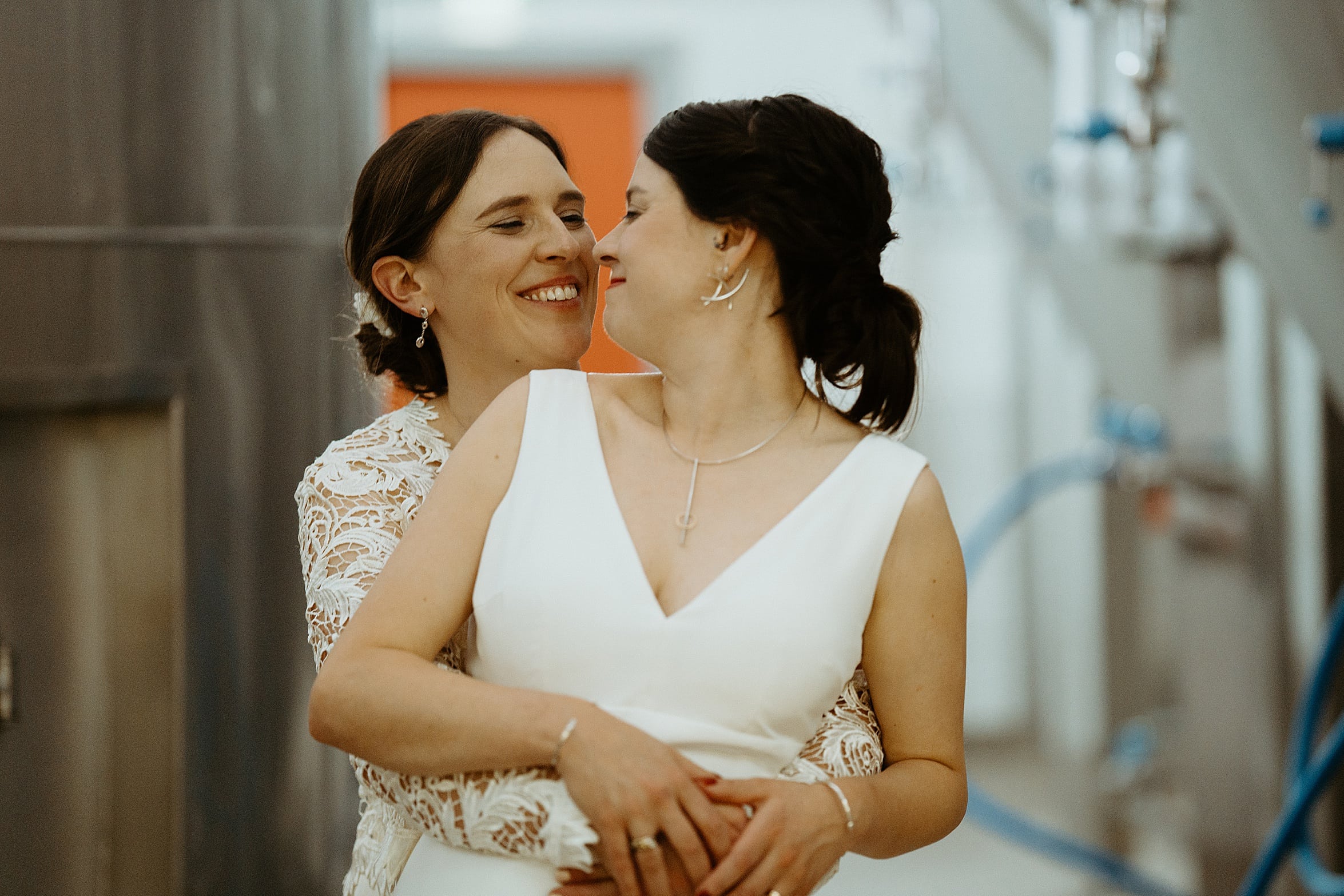 brides hugging and smiling in brewing room west brewery wedding exclusive use wedding venues scotland
