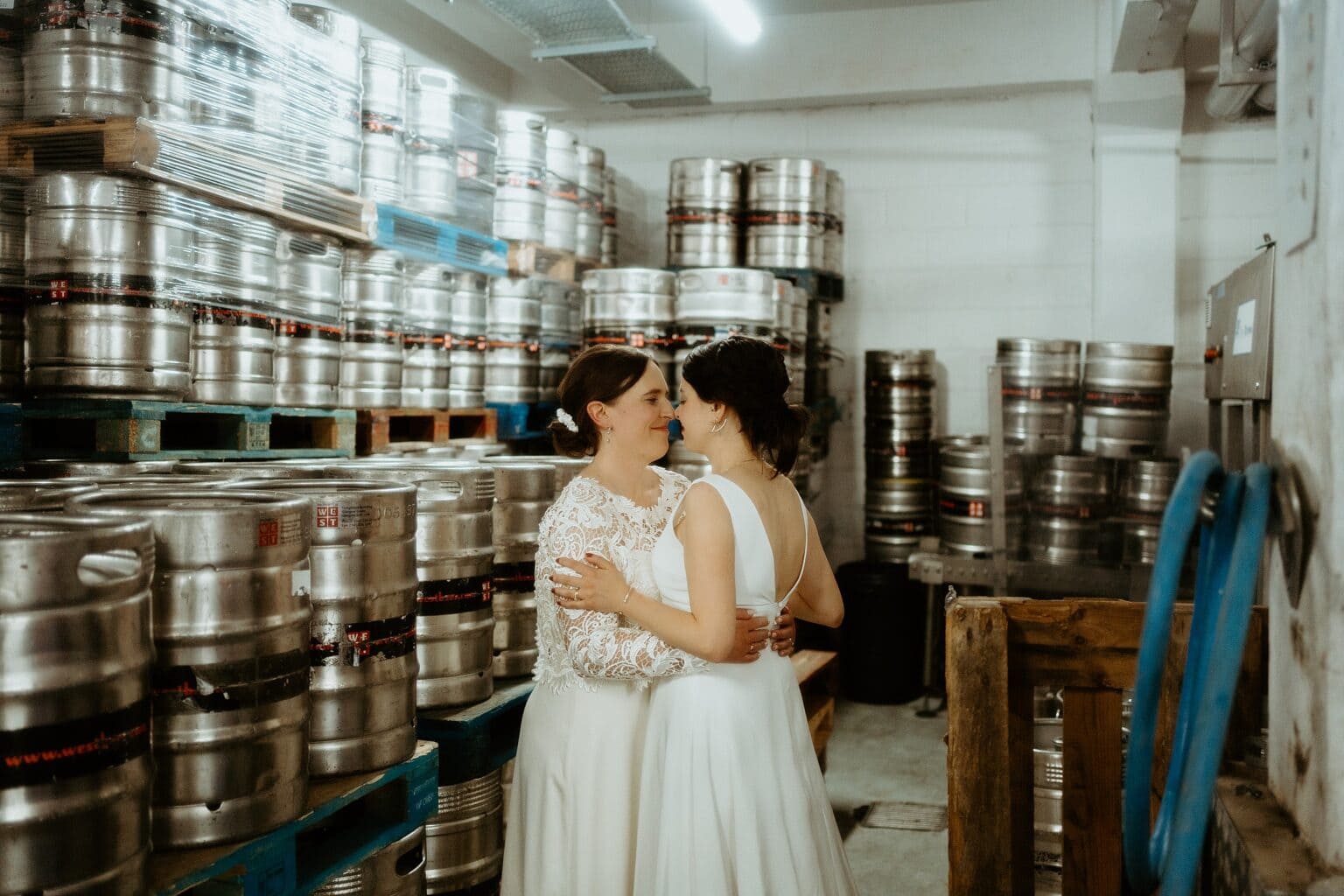 brides hugging and facing each other in room of beer casks west on the green wedding unique wedding venues glasgow