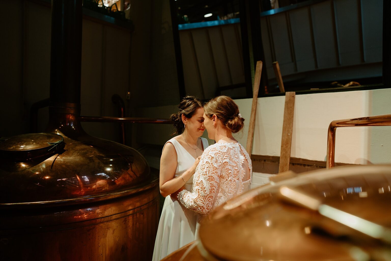 brides touch noses as they hug in brewery room west on the green wedding