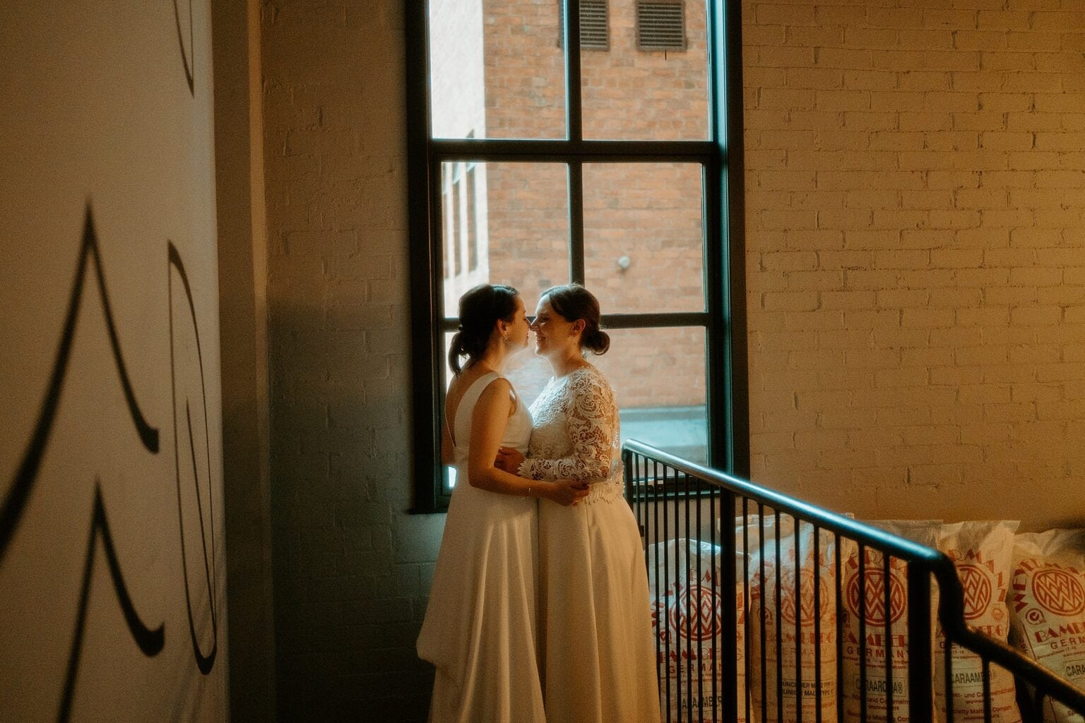 brides standing in front of large window in a warm light west on the green wedding exclusive use wedding venues scotland