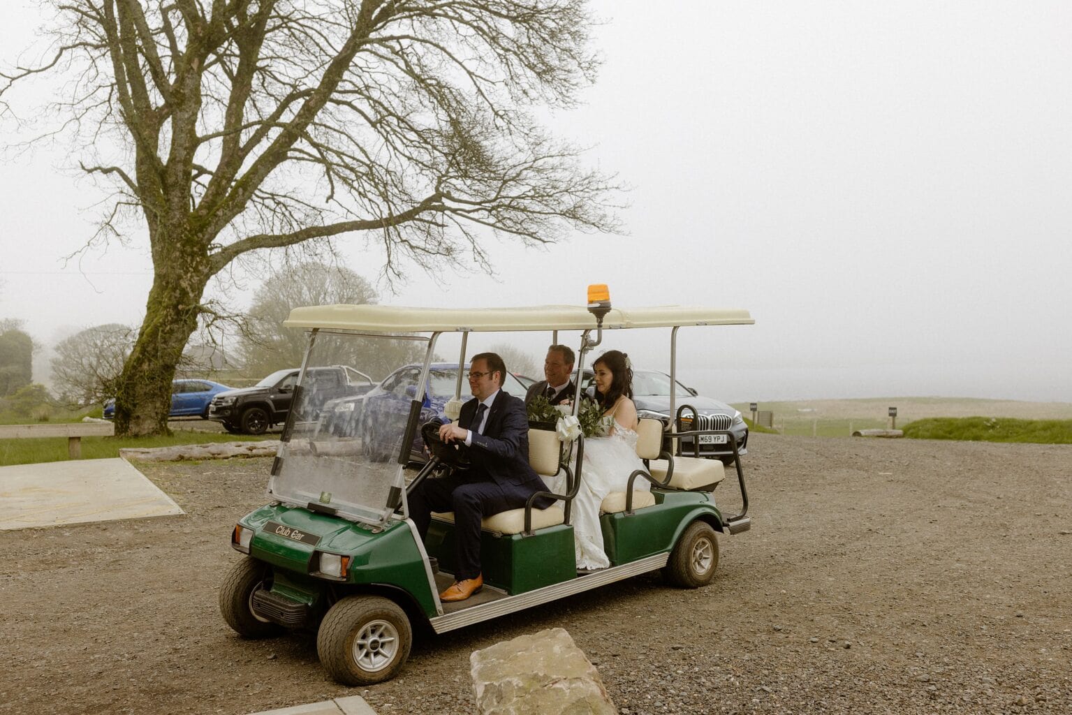 the bride and her father arrive for the wedding ceremony at barn wedding venues west lothian in a green golf cart