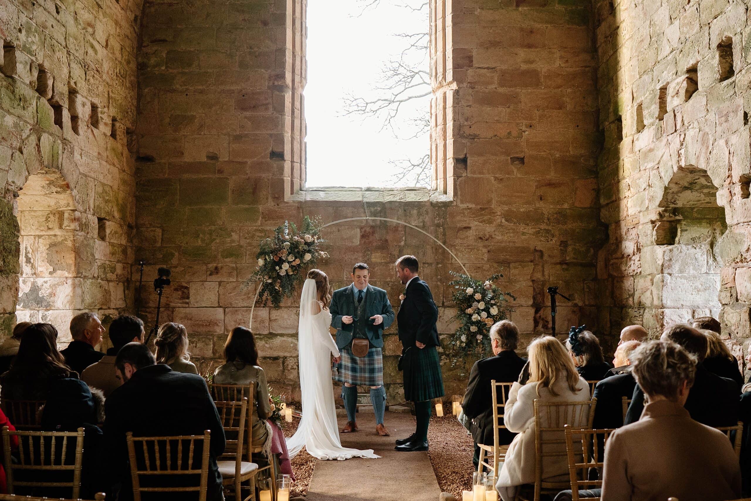 internal inside view of dunglass estate wedding photos chapel church scotland with floral arch backdrop