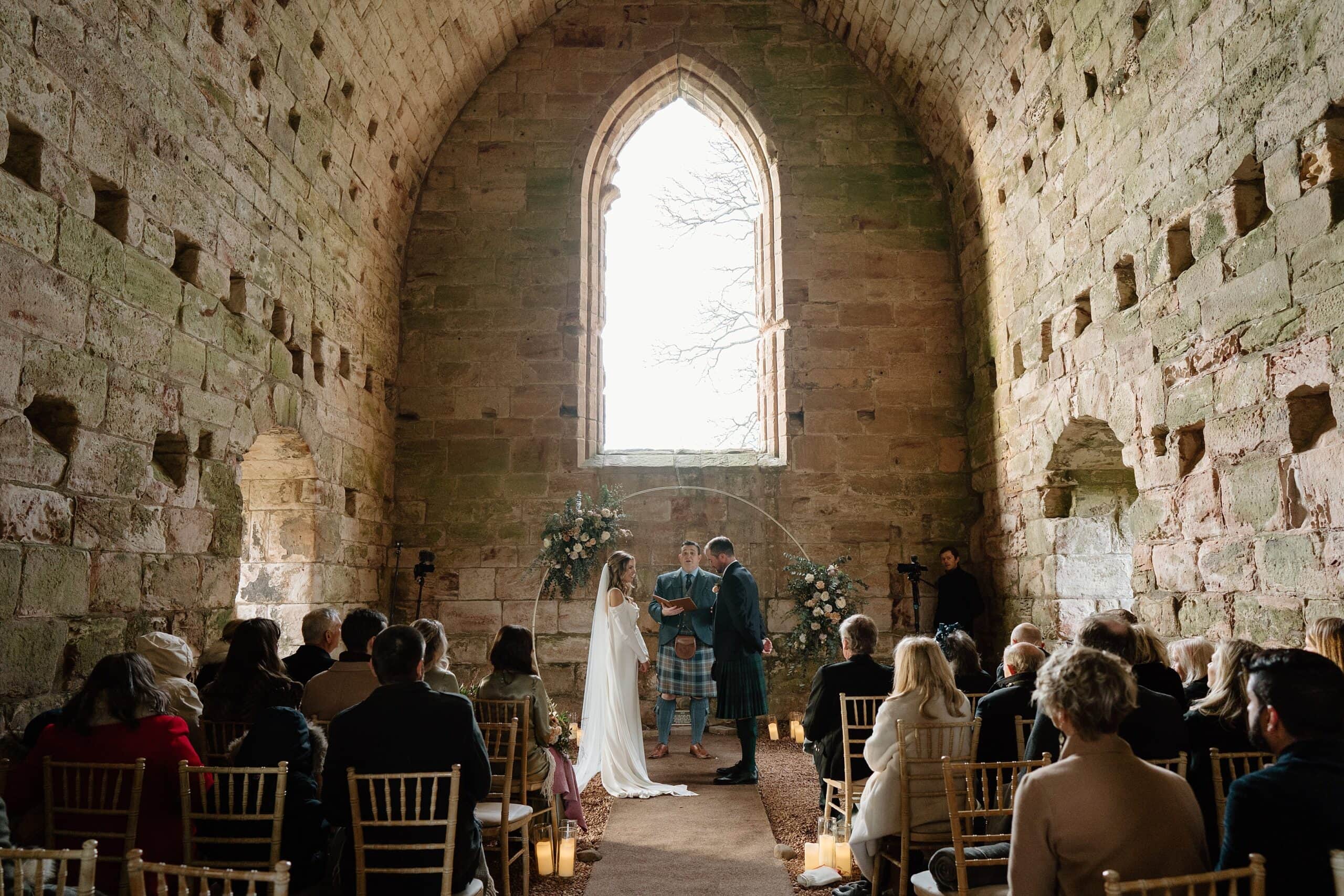 internal inside view of dunglass estate wedding photos chapel church scotland with floral arch backdrop