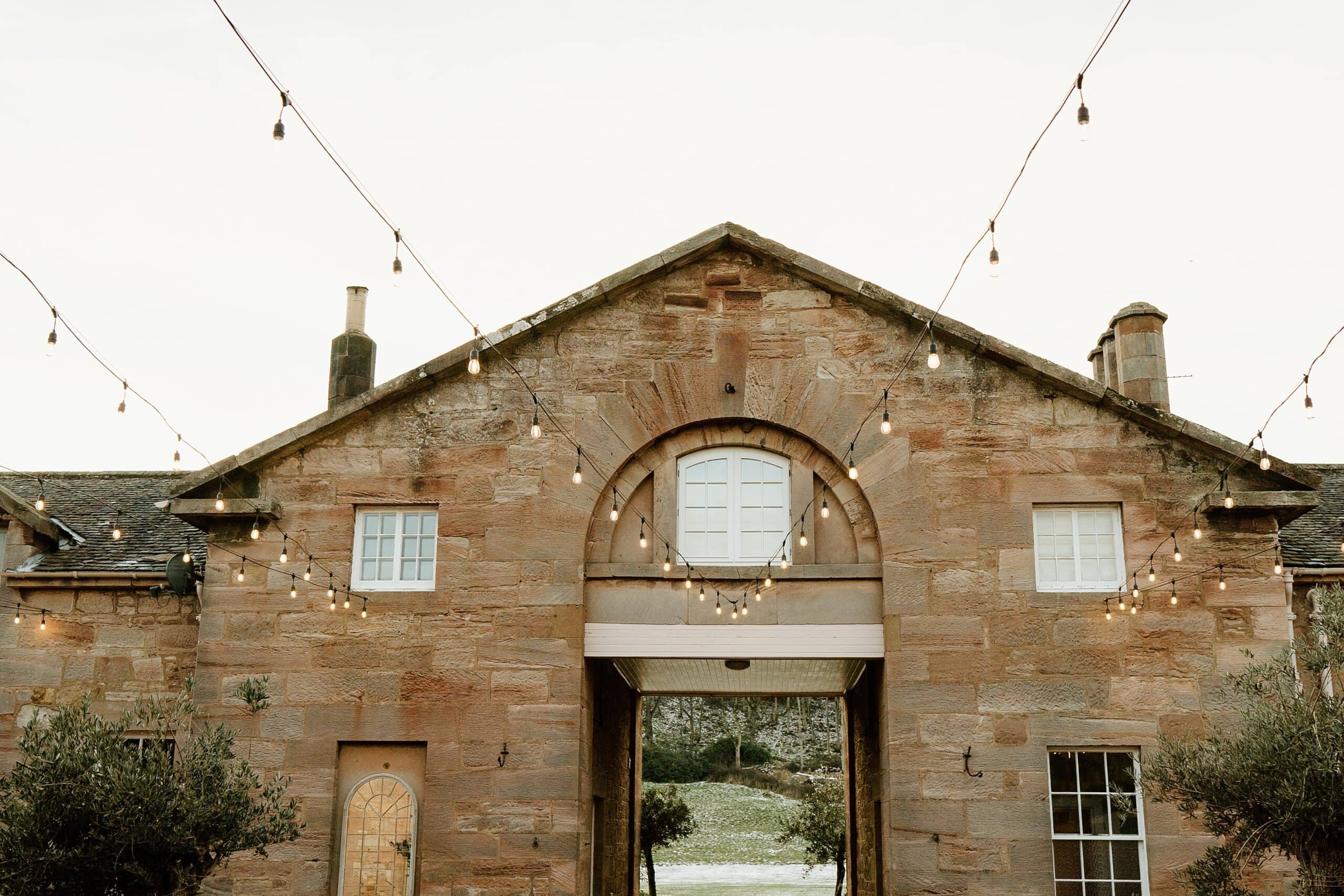 external outside view of dunglass estate wedding photos of courtyard scotland with festoon lighting