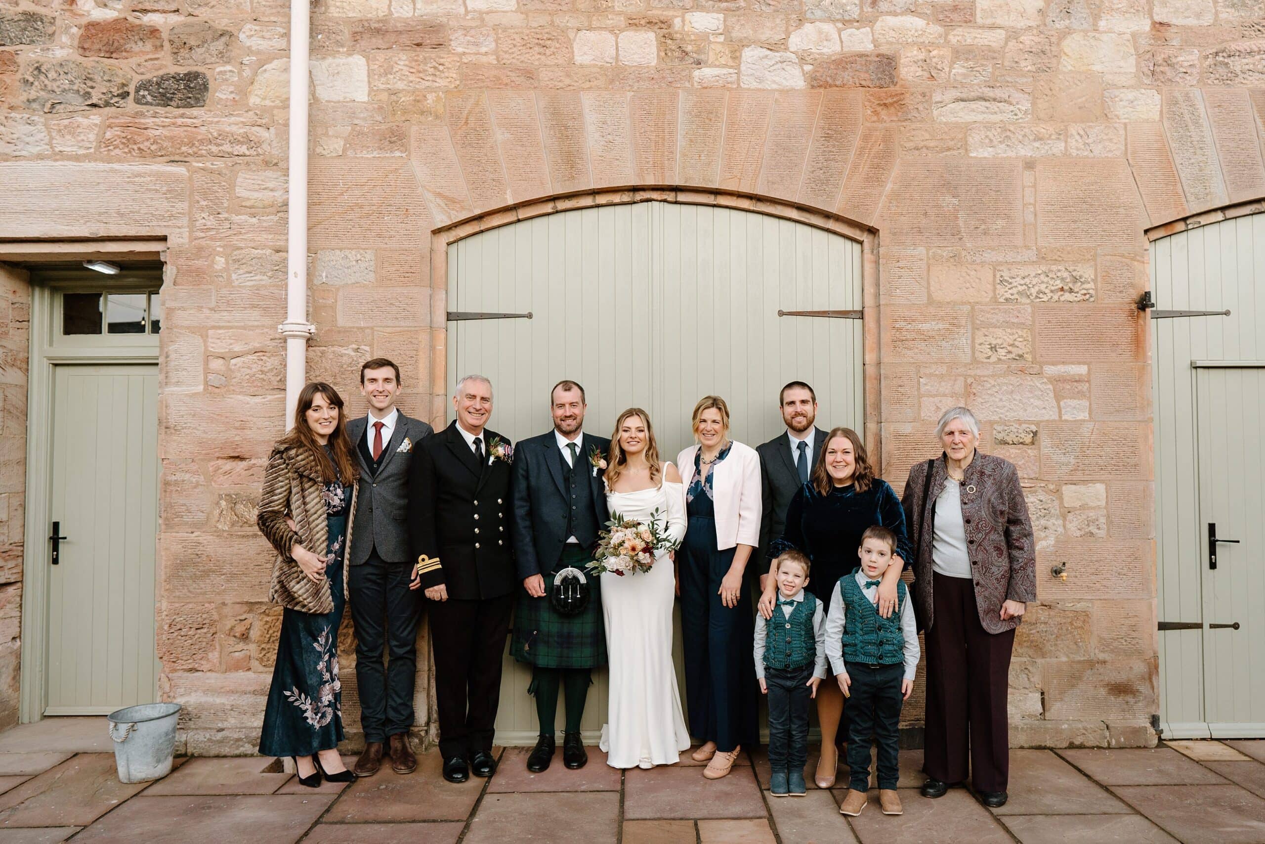 external outside view of dunglass estate wedding photos of courtyard scotland with family portraits in front of green barn doors