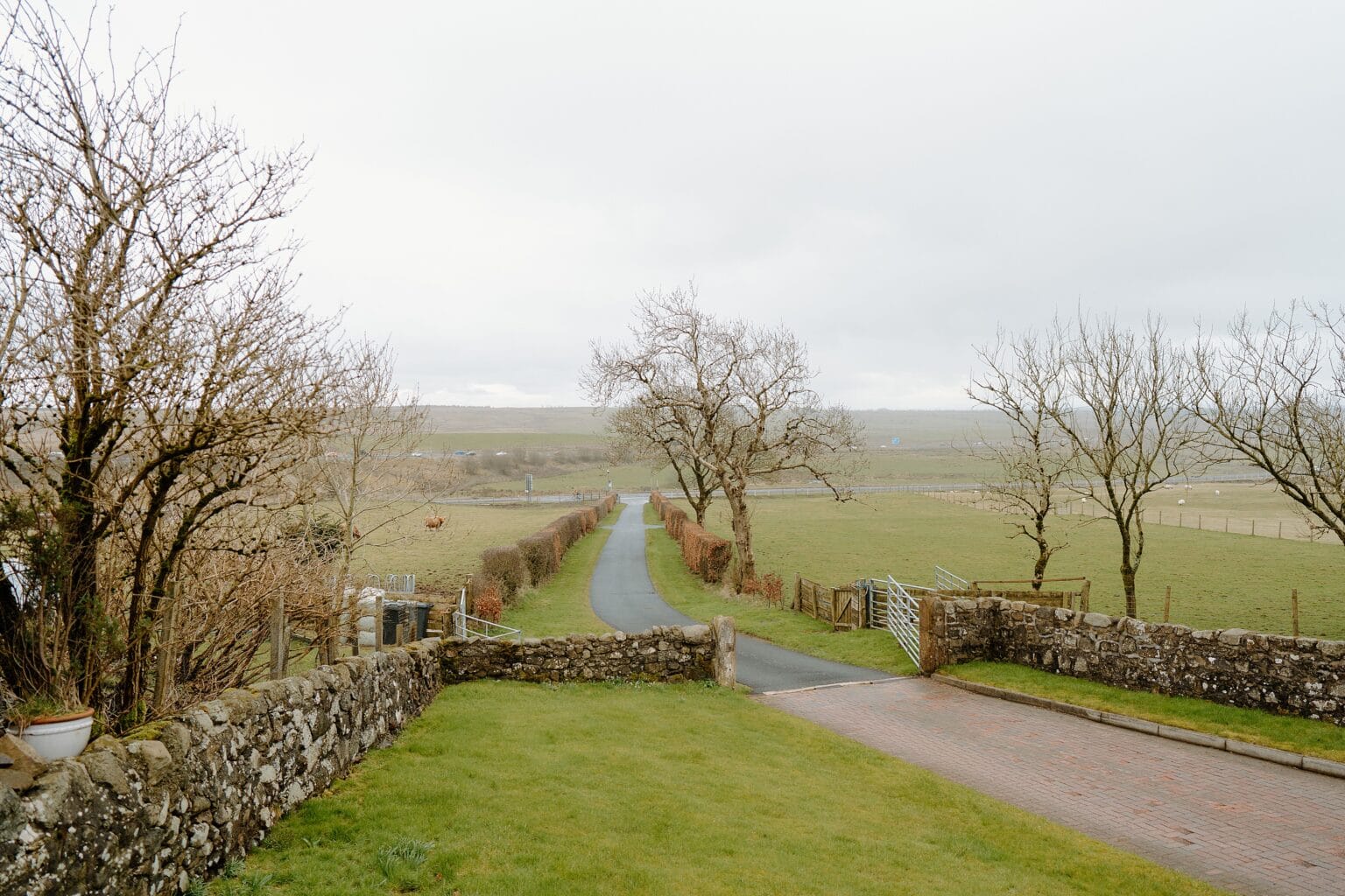 country path with fields and trees on either side outside farm wedding venues scotland on a cloudy spring day