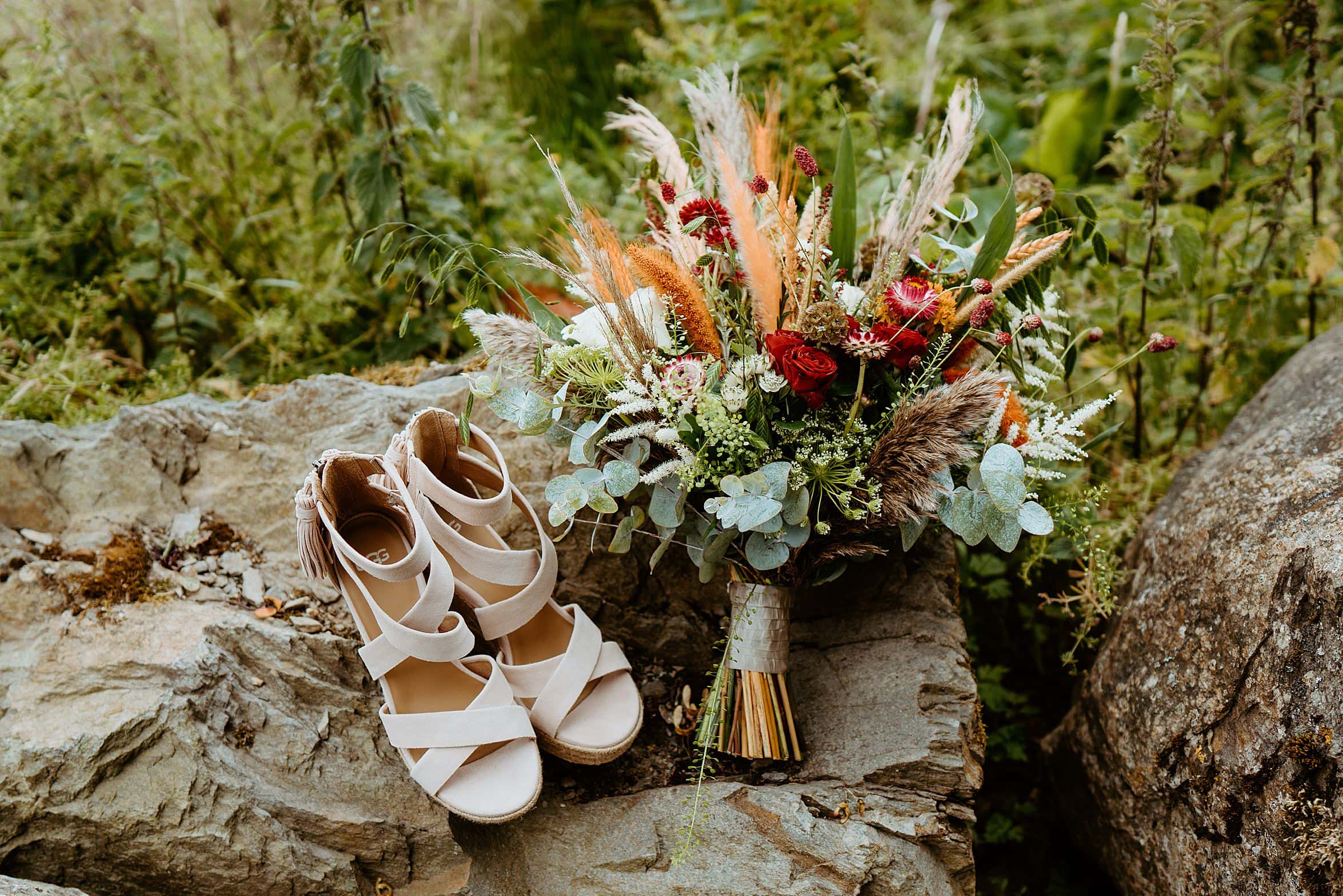 brides wedding shoes and floral bouquet on rocks outside cardney steading wedding photography