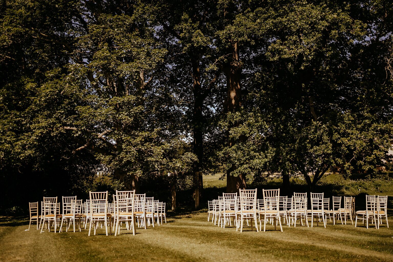 view of cremony location before guests arrive chairs on lawn with big trees in background colstoun house wedding unique wedding venue scotland