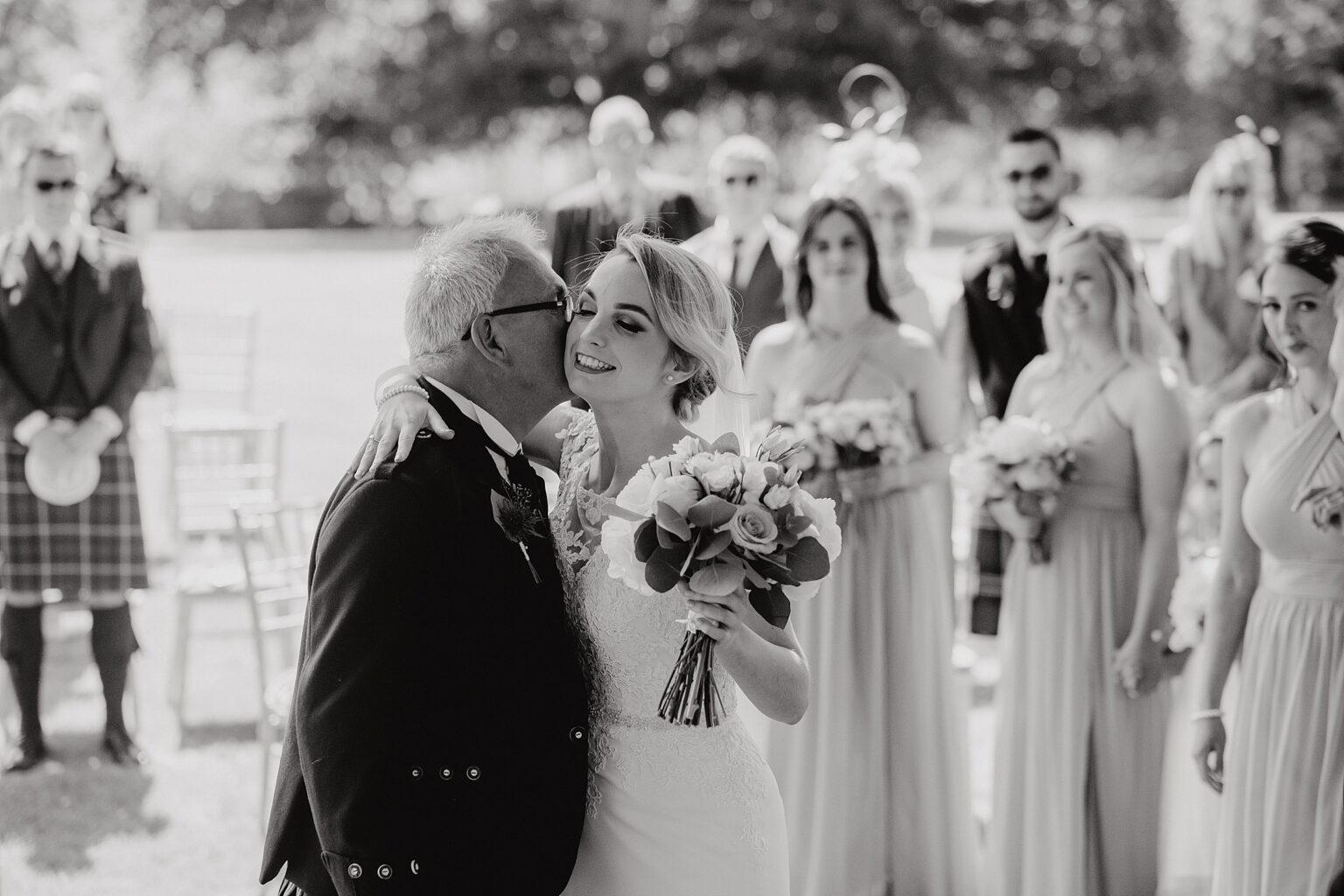 black and white photo of brides dad kissing her cheek after he walked her down the aisle colstoun house wedding cost unique wedding venue scotland