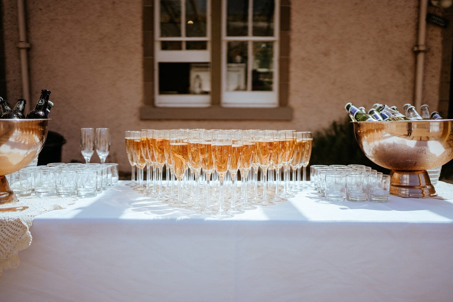 lots of glasses of champagne on white table on sunny day colstoun house wedding edinburgh unique wedding venue scotland