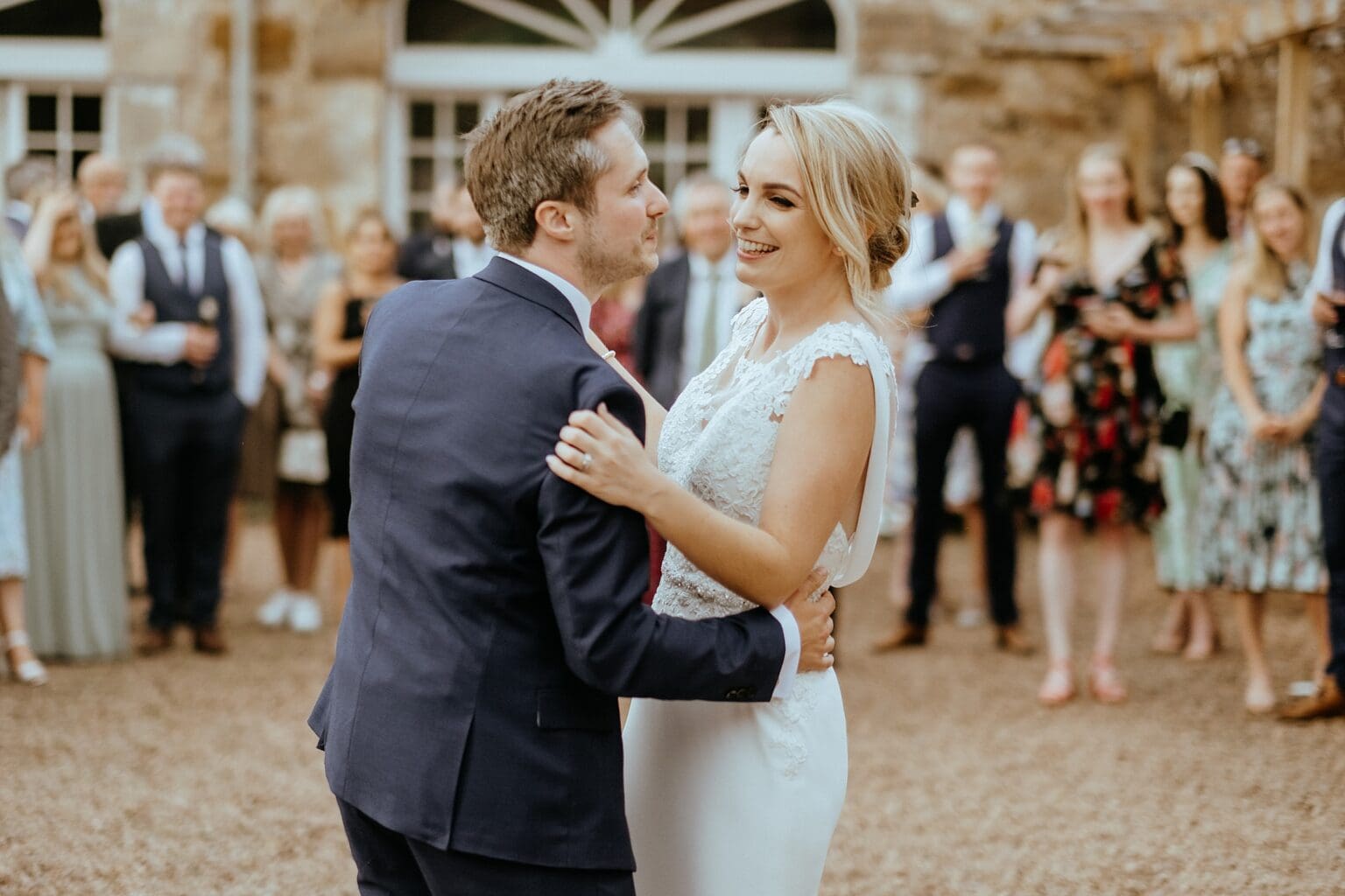 bride and groom first dance in courtyard with guests in background colstoun house wedding cost unique wedding venue scotland