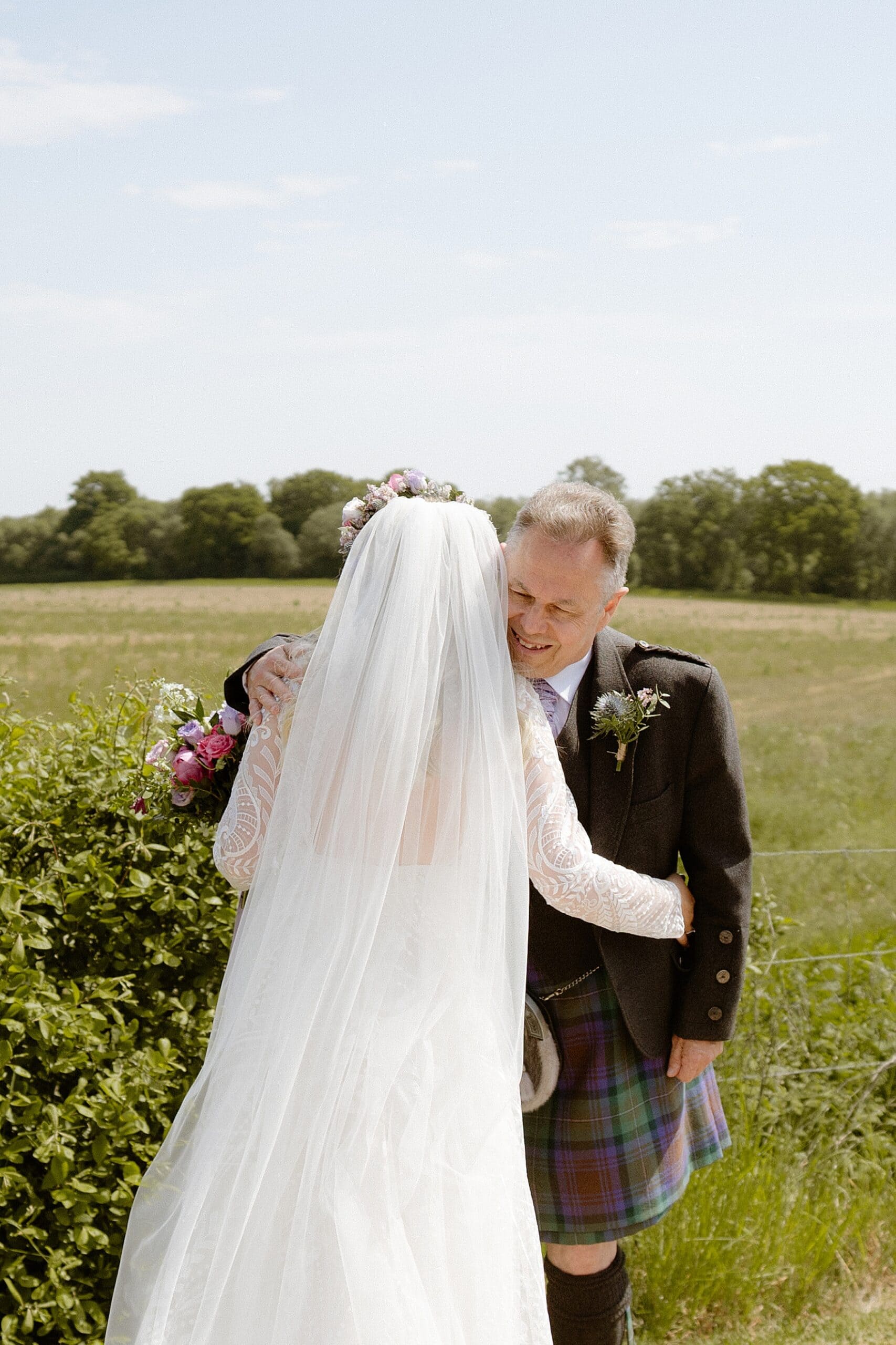 bride and her father during first look standing in front of green fields on farm at her the den at culross wedding