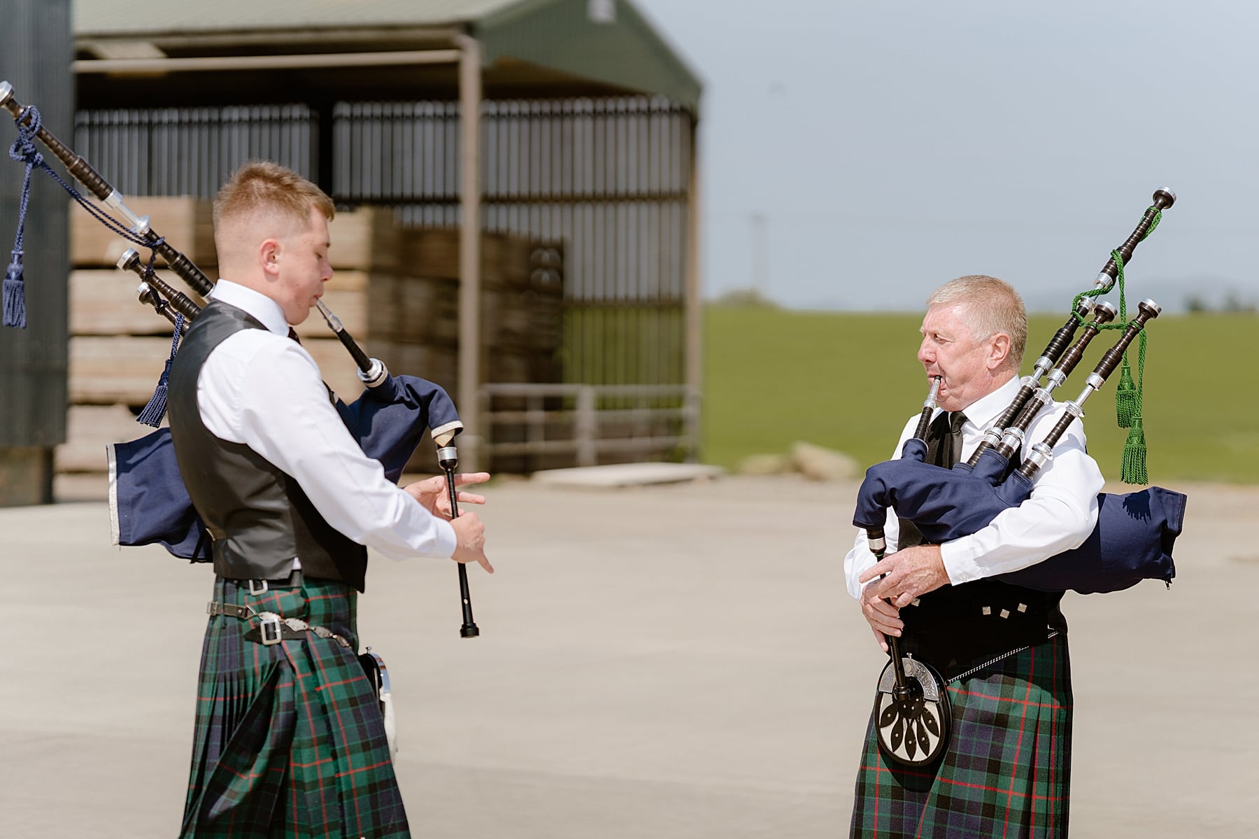 pipers outside barn at the den at culross before a Scottish barn wedding
