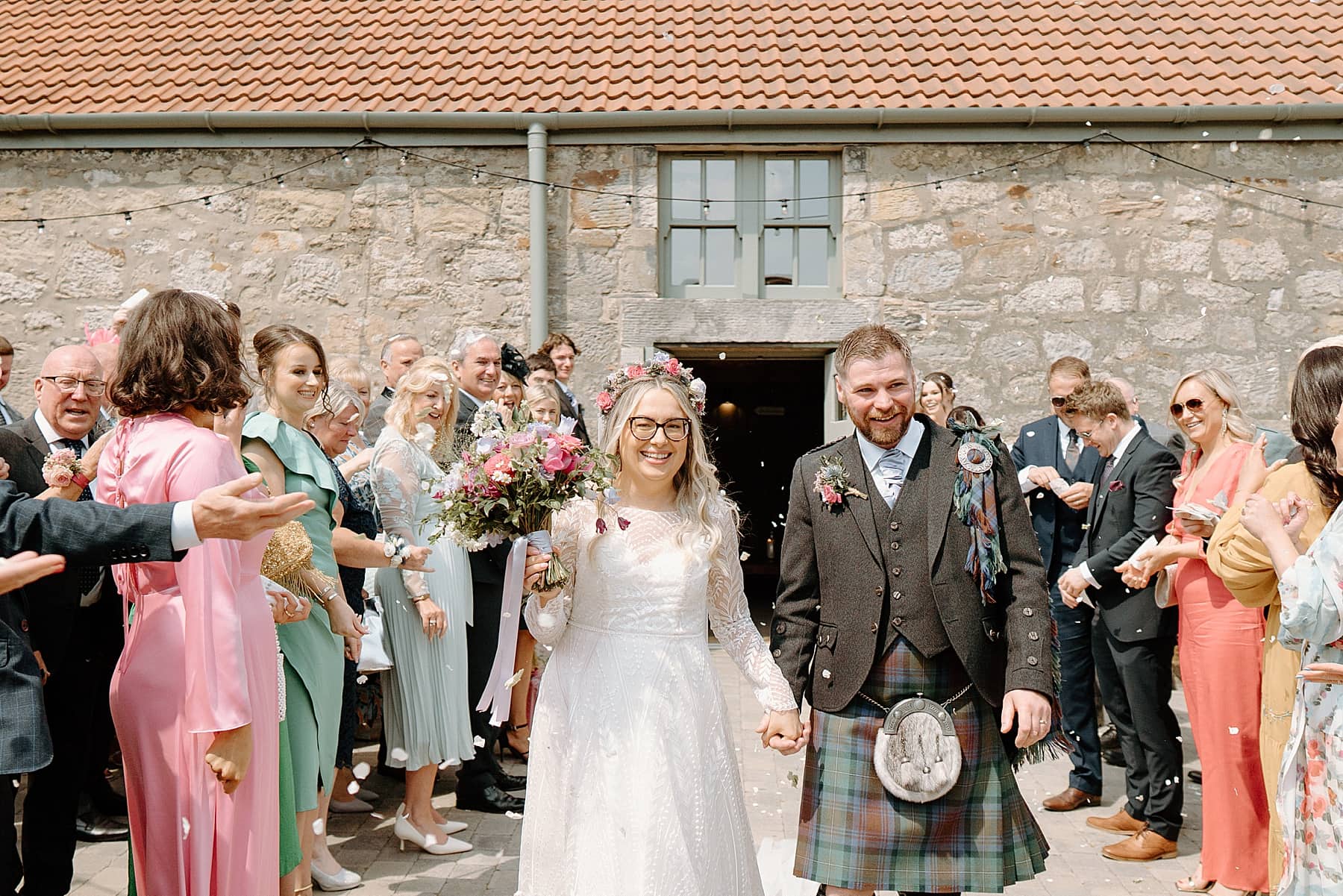 bride and groom under confetti at the den at culross wedding
