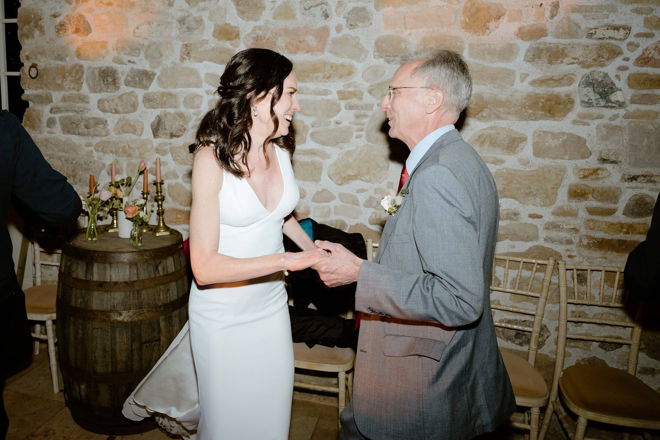 documentary shot of the bride smiling and holding hands with her father at a fun farm wedding venue near edinburgh in scotland