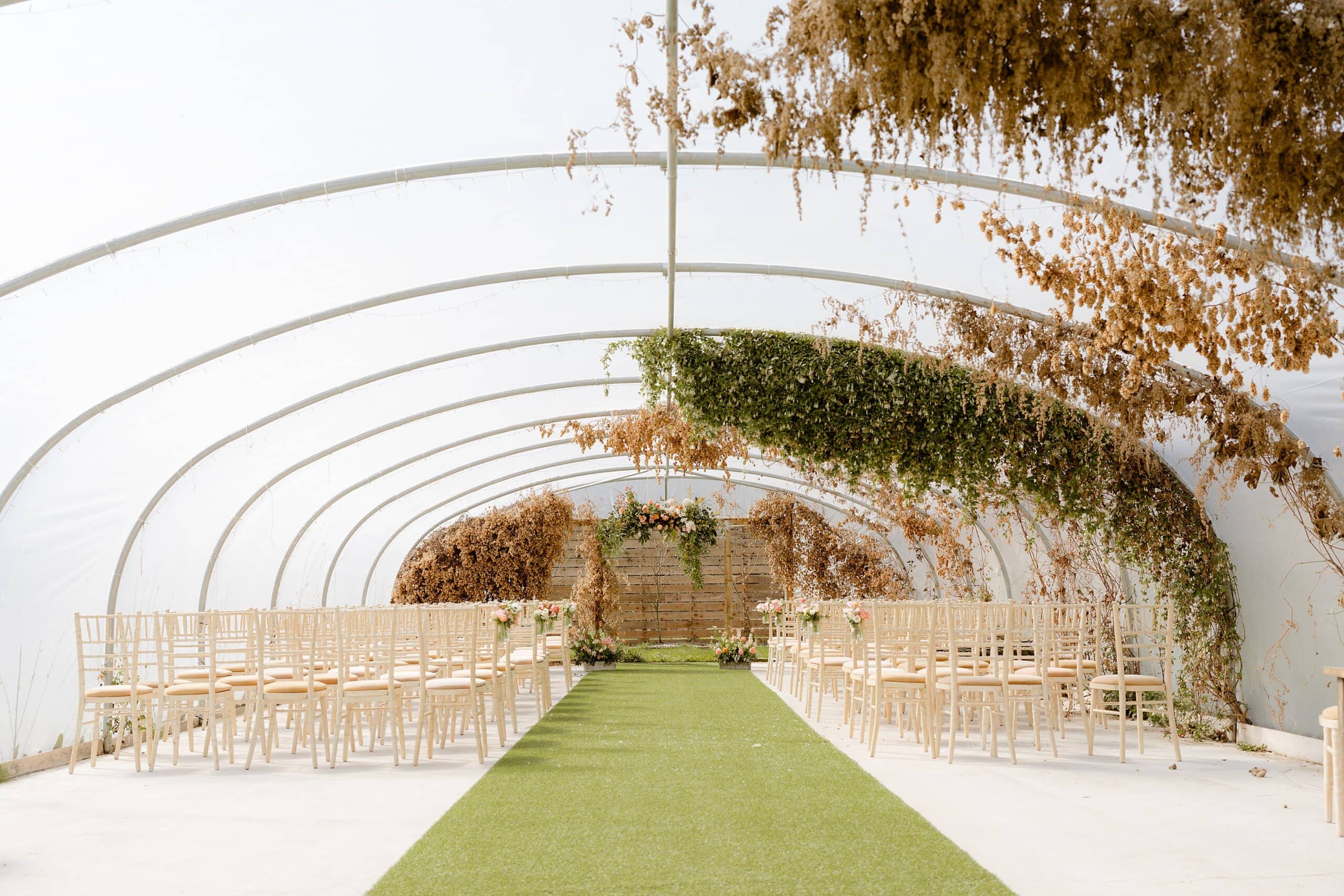 a polytunnel set with chairs and greenery for a fun relaxed wedding at a unique wedding venue near edinburgh in scotland